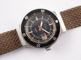 a watch that is sitting on a strap on a white surface