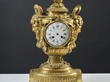 une horloge en or posée sur une table blanche