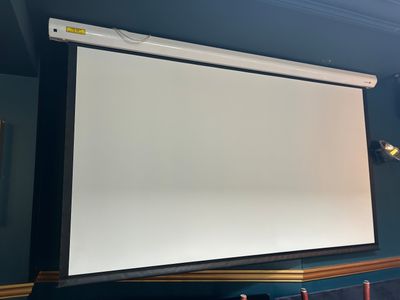L'écran de projection est accroché au mur de la pièce.