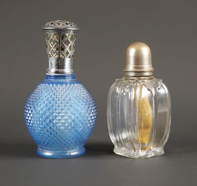 deux petites bouteilles en verre avec des bouchons argentés et une bouteille en verre bleue avec un bouchon doré