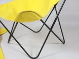 a yellow chair with a black frame and a yellow blanket