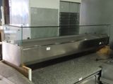 plan de travail en acier inoxydable avec une vitrine en verre dans une cuisine professionnelle