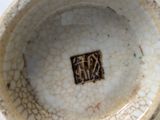 a close up of a white bowl with a brown design on it