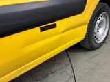 a close up of a yellow car parked on the side of the road