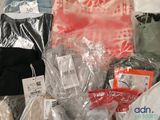 many bags of clothing that are wrapped in plastic