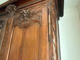 une grande armoire en bois ornée de sculptures sur le dessus