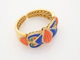 a close up of a gold ring with blue, orange and green stones