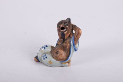 une petite figurine représentant un chien posée sur une surface blanche
