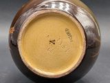 a close up of a brown vase on a table