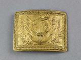 a close up of a gold belt buckle with a bird on it