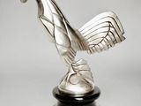 a close up of a silver statue of a rooster on a black base