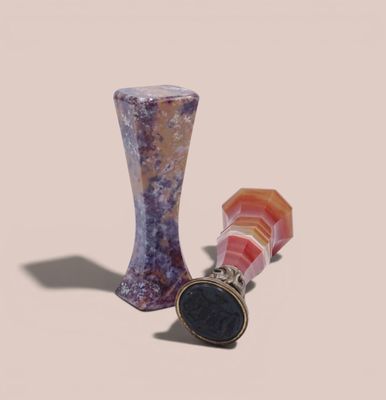 un vase en verre et une bague posés l'un à côté de l'autre