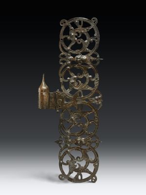 une image représentant un objet métallique très ancien posé sur une surface blanche