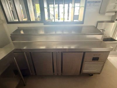 a stainless steel counter in a kitchen with a window in the background