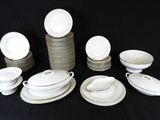 a lot of white plates and bowls on a table