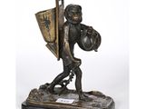 une figurine en bronze représentant un garçon portant un panier et un bouclier