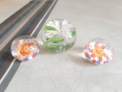 trois vases en verre posés sur une table, contenant des fleurs