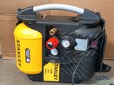 a yellow and black air compressor sitting on the ground