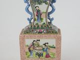 a vase with a painting on it sitting on a table