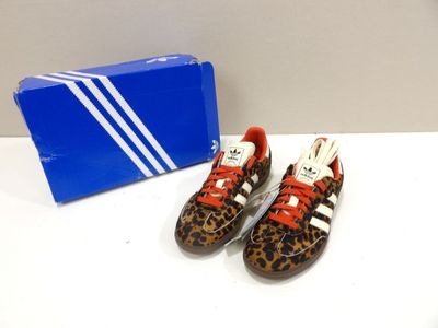 pair of adidas superstar shoes with leopard print on them next to a box of adidas superstar shoes