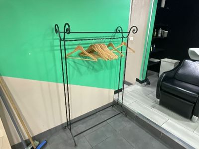 un porte-vêtements sur lequel sont suspendus des vêtements, dans une salle de bains