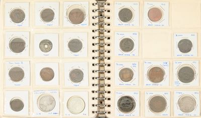 un livre ouvert sur lequel sont posées plusieurs pièces de monnaie différentes