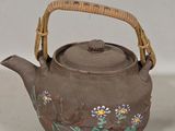 a brown tea pot with a handle and a handle on it