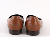 tan leather loafers with black soles on a white background