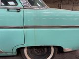 a blue car parked in a garage with its door open