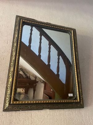 un miroir accroché au mur à côté d'un escalier
