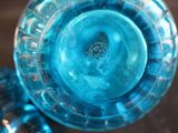 a close up of a blue glass vase on a table
