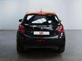 the back end of a black car with orange trims in a room