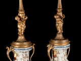 pair of gold and blue vases with figures on them against a black background