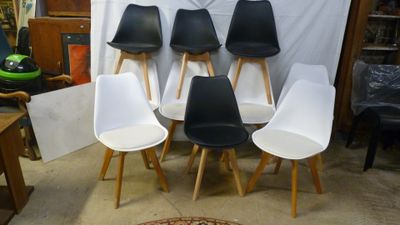 several white and black chairs sitting in front of a white backdrop