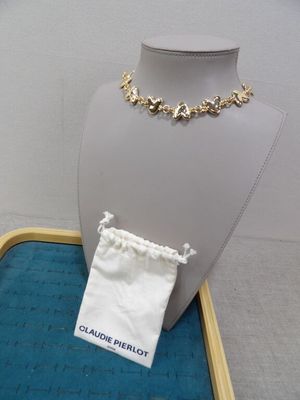 un collier et un sac exposés sur une table