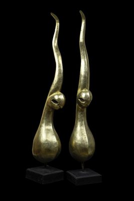 a pair of bronze sculptures of a woman ' s head and a man ' s head