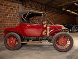 a red car parked in a garage with other cars in the background