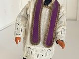 a figurine of a priest wearing a purple stoler