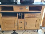 two microwaves sitting on top of a wooden cabinet
