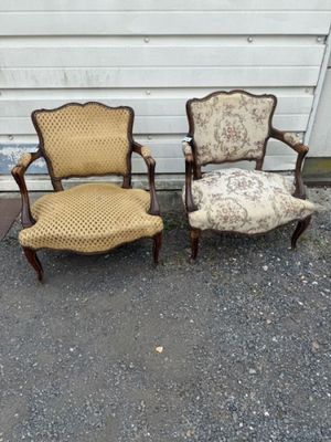 Deux chaises et une chaise avec un coussin sont posées devant un garage.