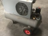 un petit compresseur d'air posé sur un chariot dans un entrepôt
