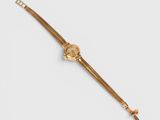 a close up of a gold wrist watch on a white surface