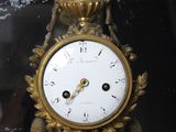 a gold clock sitting on top of a table