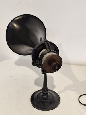 une lampe noire posée sur une table, avec un fil