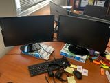 a desk with two computer monitors and a keyboard on it