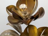 a vase with a metal flower on it on a table