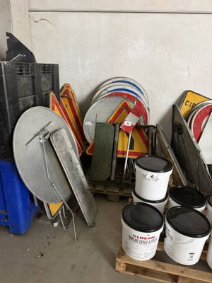 de nombreux seaux de peinture posés sur une palette dans un garage