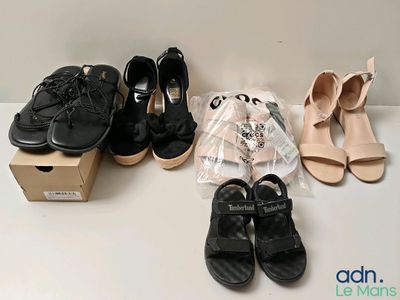 Plusieurs paires de chaussures pour femmes sont alignées sur une table
