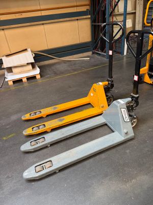 two forklifts that are sitting on the floor in a warehouse