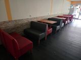 tables and chairs are lined up in a row in a restaurant